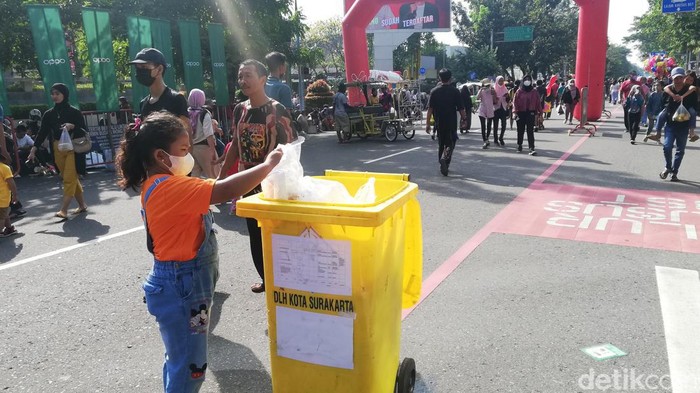 Pengunjung Solo Car Free Day membuang sampah di tempat sampah yang tersedia, Minggu (12/6/2022).