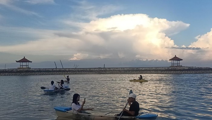 Sejumlah wisatawan bermain kano bening di Pantai Karang Sanur, Bali, pada Sabtu (11/6/2022) sore.