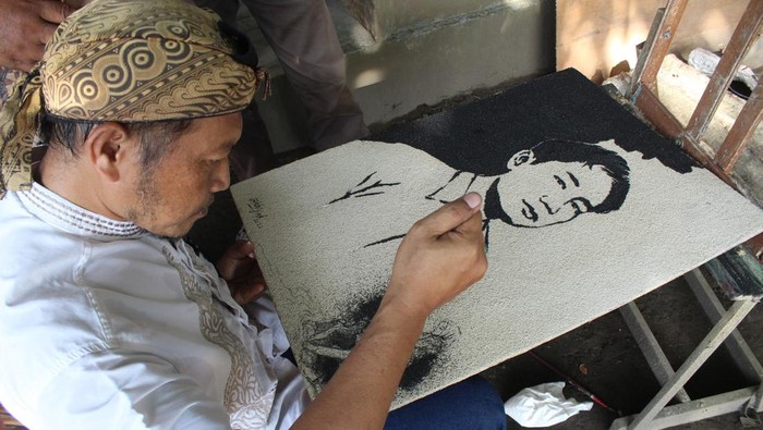 Perupa M Akhyak menyelesaikan lukisan mendiang anak Ridwan Kamil, Emmeril Khan Mumtadz di Dusun Tambakberas, Desa Tambakrejo, Kabupaten Jombang, Jawa Timur, Sabtu (11/6/2022). Lukisan pasir tersebut dibuat untuk mengenang almarhum Emmeril Khan Mumtadz serta sebagai bentuk apresiasai kepada Gubernur Jabar Ridwan Kamil yang begitu tabah menerima musibah tersebut. ANTARA FOTO/Syaiful Arif/nym.