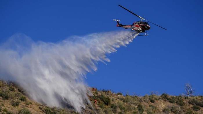 California Wildfire A helicopter drops water on the Sheep Fire burning in Wrightwood, Calif., Sunday, June 12, 2022. (AP Photo/Ringo H.W. Chiu)