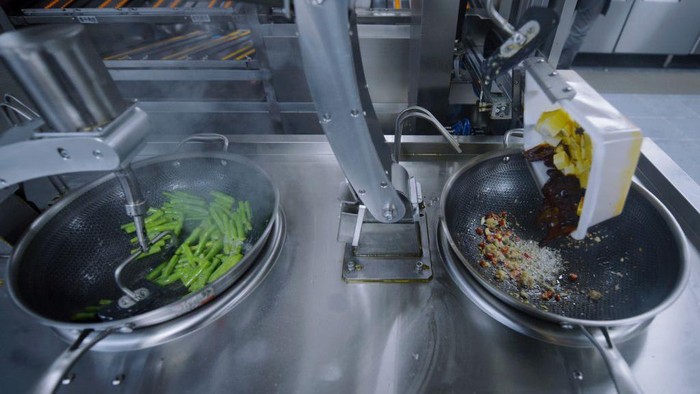 Canggih! Restoran di China Pekerjakan Koki Robot HANGZHOU, CHINA - JUNE 13, 2022 - A stir-frying robot cooks dishes for customers at a robot restaurant in Xihu District of Hangzhou, East China's Zhejiang Province, June 13, 2022. It is understood that the robot cooking system is independently developed by the scientific research staff of the restaurant and has certain AI learning ability, in which the manipulator is responsible for grabbing ingredients and seasonings, and three cooking robots can be started at the same time, realizing the flow mode of Chinese cooking process while maintaining the stability of cooking dishes. From the time a customer places an order to the time the dish is put on the plate, the robot will take no more than three minutes on average to cook a single dish. So far, the robot restaurant has 20 dishes to choose from. (Photo credit should read CFOTO/Future Publishing via Getty Images)