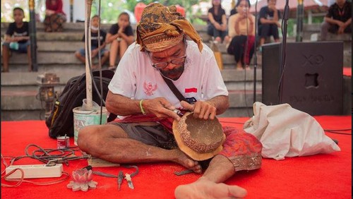 Para peserta terlihat fokus mengerjakan kerajinan beruk yang dilombakan di Kalangan Ayodya Taman Budaya Provinsi Bali (Art Center), Senin (13/6/2022).
