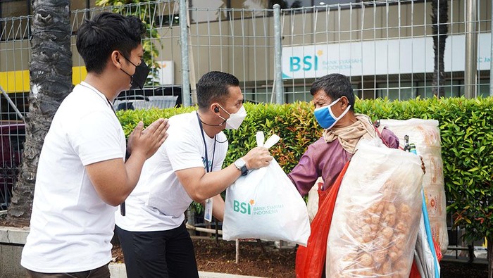 Pegawai Milenial PT Bank Syariah Indonesia Tbk (BSI)memberikan paket sembako kepada masyarakat kurang mampu di Jakarta, Senin (13/6).