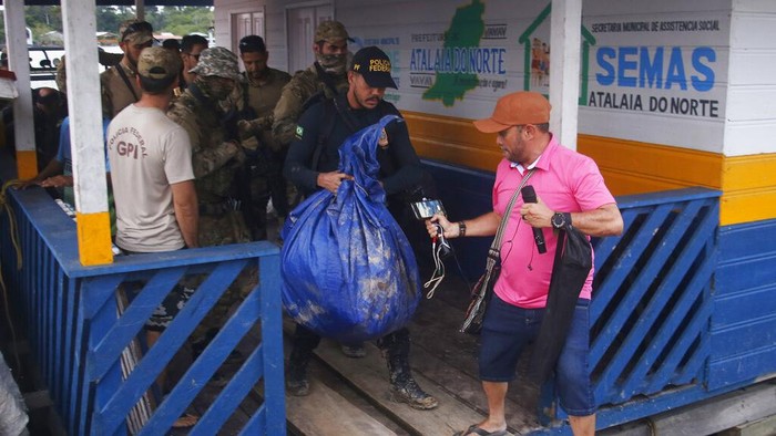 Federal police officers arrive at the pier with items found during a search for Indigenous expert Bruno Pereira and freelance British journalist Dom Phillips in Atalaia do Norte, Amazonas state, Brazil, Sunday, June 12, 2022. Divers from Brazils firefighters corps found a backpack and laptop Sunday in the remote Amazon area where Pereira and Phillips went missing a week ago, firefighters said. (AP Photo/Edmar Barros)