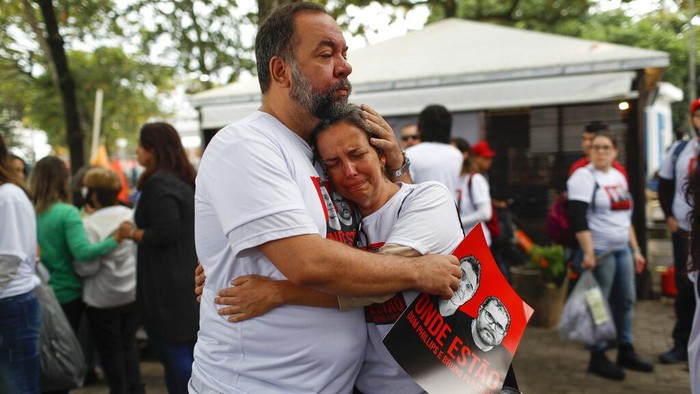 Luis Fabiano and Flavia Farias, relatives of British journalist Dom Phillips´ wife, embrace during a protest following the disappearance, in the Amazon, of Phillips and expert on indigenous affairs Bruno Araujo Pereira, in Copacabana beach, Rio de Janeiro, Brazil, Sunday, June 12, 2022. Federal Police and military forces are carrying out searches and investigations into the disappearance of Phillips and Pereira in the Javari Valley Indigenous territory, a remote area of the Amazon rainforest in Atalaia do Norte, Amazonas state. (AP Photo/Bruna Prado)