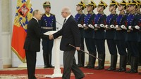 Presiden Vladimir Putin menyalami aktor dan sutradara film Nikita Mikhalkov dalam perayaan tersebut, Minggu (12/6/2022). Isu kemunduran kesehatan Putin pascakemunculannya yang tak biasa saat bertemu dengan Presiden Belarusia Alexander Lukashenko. Saat itu, ia disebut seperti tak nyaman.  