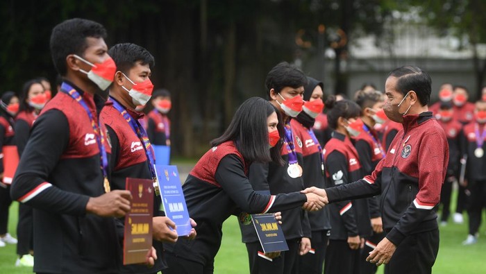 Presiden Joko Widodo (kanan) berjabat tangan dengan karateka peraih medali perak Ceyco Georgia Hutagalung (ketiga kiri) saat upacara penyerahan bonus atlet SEA Games ke-31 Vietnam di Halaman Istana Merdeka, Jakarta, Senin (13/6/2022). Presiden menyerahkan total bonus kepada seluruh atlet sebesar Rp130,5 Miliar sementara untuk pelatih dan asisten pelatih sebesar Rp32 Miliar. ANTARA FOTO/Akbar Nugroho Gumay/nz