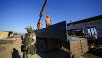 Pekerja konstruksi melakukan bongkar muat truk di lokasi pembangunan sebuah rumah sakit yang dibangun dengan dukungan Kementerian Pertahanan Rusia di Luhansk, di wilayah yang berada di bawah kendali Pemerintah Republik Rakyat Luhansk, Ukraina timur, Sabtu, (11/6/2022).