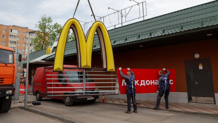 Workers use a crane to dismantle the McDonald's Golden Arches while removing the logo signage from a drive-through restaurant of McDonald's in the town of Kingisepp in the Leningrad region, Russia June 8, 2022. REUTERS/Anton Vaganov