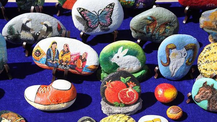 Unik! Bukan di Kanvas, Lukisan Ini Ada di Atas Batu YIWU, CHINA - JUNE 13, 2022 - A folk artist paints on a stone in Yiwu, Xinjiang Province, China, June 13, 2022. The content involves folk custom, specialty, character creation, heroes fighting the epidemic, customs and so on. (Photo credit should read CFOTO/Future Publishing via Getty Images)