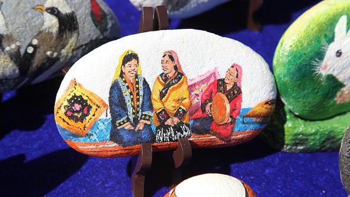 Unik! Bukan di Kanvas, Lukisan Ini Ada di Atas Batu YIWU, CHINA - JUNE 13, 2022 - A folk artist paints on a stone in Yiwu, Xinjiang Province, China, June 13, 2022. The content involves folk custom, specialty, character creation, heroes fighting the epidemic, customs and so on. (Photo credit should read CFOTO/Future Publishing via Getty Images)