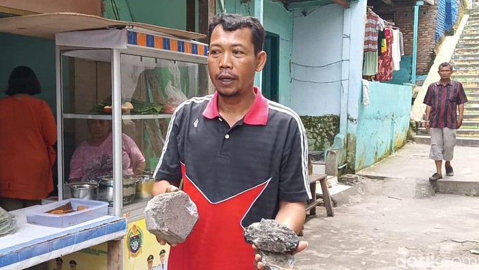 Warga Kampung Aur menunjukkan batu yang digunakan OTK menyerang rumah warga