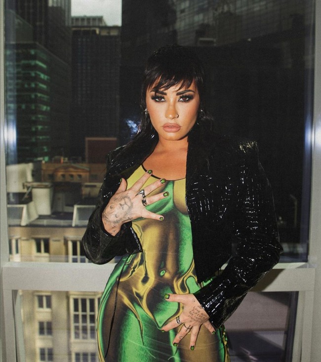  Demi Lovato merupakan artis terbaru yang ikut tren naked dress. Penyanyi yang mengaku sebagai non-biner ini memakai gaun ketat warna neon bergambar tubuh telanjang keluaran Syndical Chamber. Ia memadukannya dengan jaket hitam. Foto: Instagram