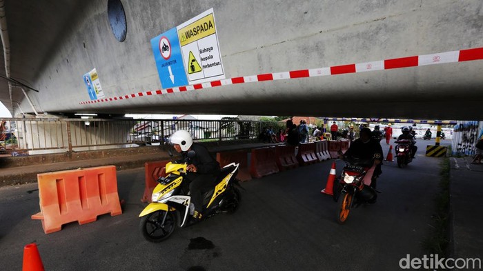 Ini Proyek Box Girder Kereta Cepat yang 'Mepet' Jembatan di Bekasi Petugas mengatur lalu lintas kendaraan yang melintas di Jembatan Antelope, Curug, Bekasi, Jawa Barat, Selasa (14/6/2022). Pengaturan lalu lintas karena adanya pemasangan girder proyek kereta cepat dan hanya dapat dilalui kendaraan dengan ketinggian maksimal 1,7 meter dari tanggal 13 Juni hingga 10 Agustus 2022.