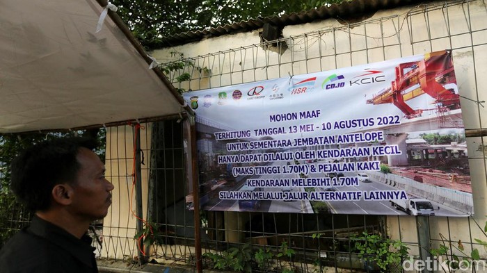 Ini Proyek Box Girder Kereta Cepat yang 'Mepet' Jembatan di Bekasi Petugas mengatur lalu lintas kendaraan yang melintas di Jembatan Antelope, Curug, Bekasi, Jawa Barat, Selasa (14/6/2022). Pengaturan lalu lintas karena adanya pemasangan girder proyek kereta cepat dan hanya dapat dilalui kendaraan dengan ketinggian maksimal 1,7 meter dari tanggal 13 Juni hingga 10 Agustus 2022.