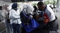 Petugas memeriksa menonton yang akan masuk ke Istora Senayan.