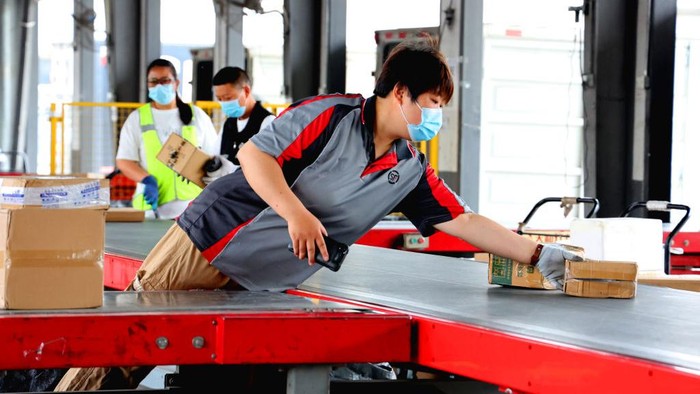 Kesibukan Jelang Festival Belanja Online 18 Juni di China LIANYUNGANG, CHINA - JUNE 14: Employees sort express parcels at an express company before the '618' online shopping festival on June 14, 2022 in Lianyungang, Jiangsu Province of China. (Photo by Geng Yuhe/VCG via Getty Images)