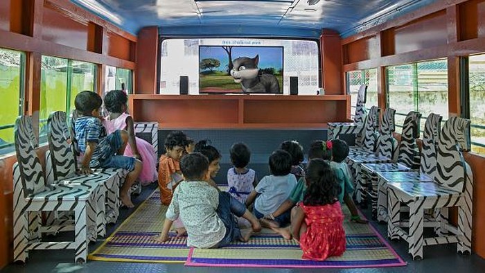 Students watch an educative video playing on a television inside a re-modified low-floor old defunct public transport bus transformed into a classroom for pre-nursery school children through an initiative Education on Wheels taken by the state government at Thiruvananthapuram in Indias Kerala state on June 13, 2022. (Photo by Manjunath Kiran / AFP) (Photo by MANJUNATH KIRAN/AFP via Getty Images)
