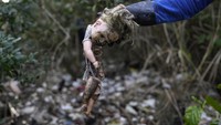 Seorang nelayan menunjukkan sebuah boneka yang rusak dan dibuang di area hutan mangrove yang ada di di Teluk Guanabara, Rio de Janeiro, Brasil.