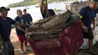 Tampak sejumlah nelayan bersama-sama mengangkat sofa bekas yang ditemukan di hutan mangrove yang ada di Teluk Guanabara, Rio de Janeiro, Brasil, untuk ditimbang.