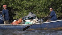 Sejumlah nelayan mengumpulkan sampah yang ditemukan dari hutan mangrove yang berada di Teluk Guanabara, Rio de Janeiro, Brasil.
