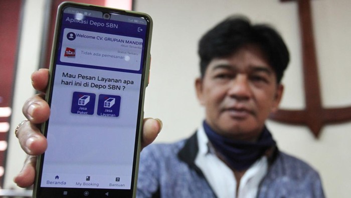 Warga menunjukkan aplikasi Depo SBN saat peluncurannya di Surabaya, Jawa Timur, Selasa (14/6/2022). Aplikasi yang diluncurkan oleh PT PBM Sarana Bandar Nasional yang merupakan anak perusahaan dari  PT Pelayaran Nasional Indonesia (Persero) itu bertujuan untuk meningkatkan layanan kepada para pengguna jasa baik pengirim barang maupun penerima barang. ANTARA FOTO/Didik Suhartono/rwa.