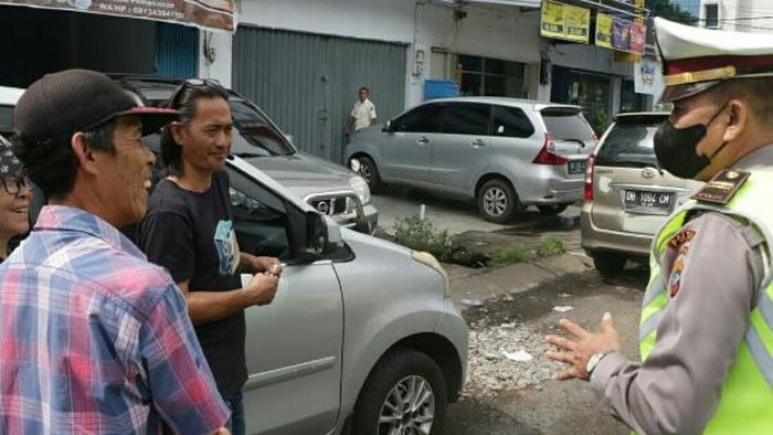 Polisi memberikan edukasi terhadap pengendara yang melanggar lalin.
