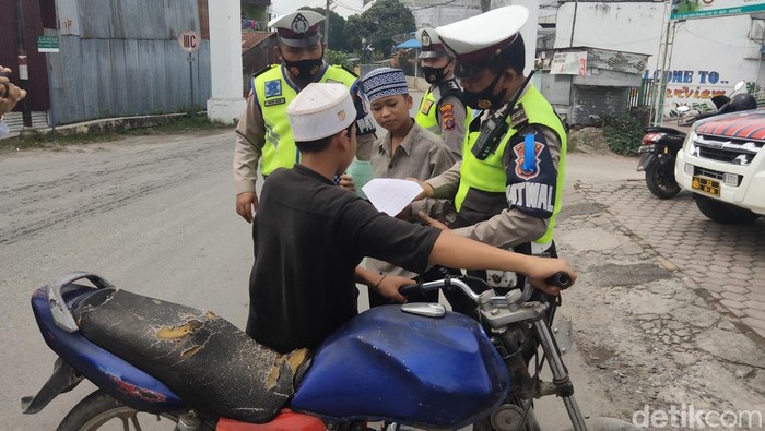 Polisi menilang anak di bawah umur yang mengendarai sepeda motor pada operasi Patuh Toba 2022 di Kisaran. (Perdana/detikSumut)