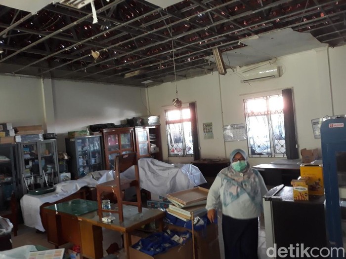 Salah seorang pegawai Dinas Kesehatan (Dinkes) Bantul saat menunjukkan kerusakan di salah satu ruangan kerja Kantor Dinkes Bantul, Selasa (14/6/2022).