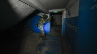 Seorang tentara Rusia memeriksa labirin pabrik baja yang berhasil dikuasai. Sebelumnya, labirin ini digunakan tentara dan milisi Ukraina saat bertahan dari serangan Rusia.