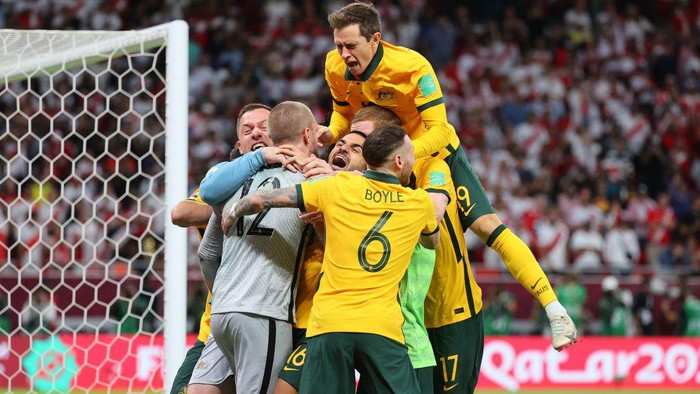 Australias players celebrate winning the FIFA World Cup 2022 inter-confederation play-offs match between Australia and Peru on June 13, 2022, at the Ahmed bin Ali Stadium in the Qatari city of Ar-Rayyan. - Australia beat Peru in a sudden death penalty shootout to secure the penultimate free place at the 2022 World Cup finals. (Photo by KARIM JAAFAR / AFP) (Photo by KARIM JAAFAR/AFP via Getty Images)