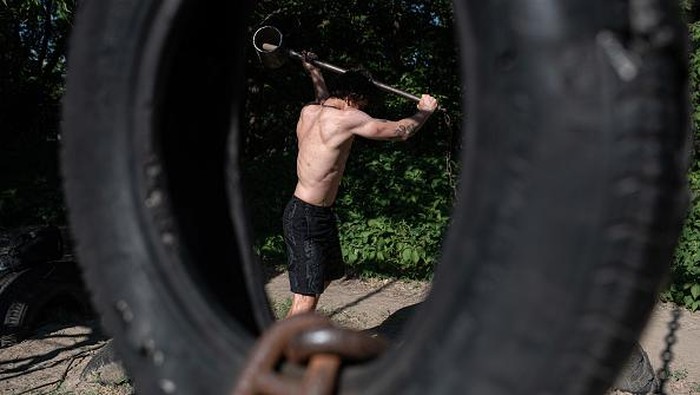 Warga Ukraina Latih Kekuatan di Gym 'Besi Tua' KYIV, UKRAINE - JUNE 13: A man works out in an outdoor gym on Hidropark on June 13, 2022 in Kyiv, Ukraine. The region around Ukraine's capital continues to recover from Russia's aborted assault on Kyiv, which turned many communities into battlefields. (Photo by Alexey Furman/Getty Images)