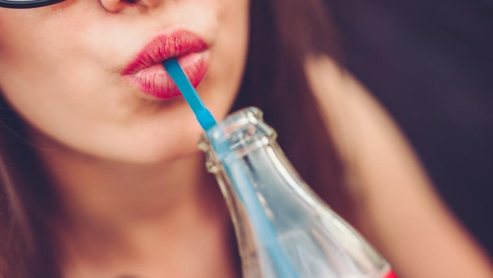 1017721348 Portrait of young caucasian woman relaxing in cafe and drinking juice. Close up.