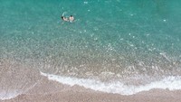 Pantai berpasir putih dengan air jernih menjadi daya tarik pantai ini.