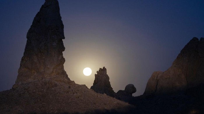 TRONA, CA - JUNE 14: In an aerial view, the Strawberry Supermoon sets behind the Trona Pinnacles, which were formed underwater when this region of the Mojave Desert was under a body of water on June 14, 2022 near Trona, California. The Strawberry supermoon is not a reference to its color but to the month in which some Native Americans harvested wild strawberries.  (Photo by David McNew/Getty Images)