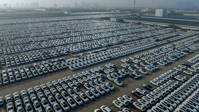 1402806704 XIANGYANG, CHINA - JUNE 13: Aerial view of new Nissan vehicles sit parked at a parking lot of Xiangyang Fengshen Logistics Co. Ltd next to the Dongfeng Nissan Passenger Vehicle Company on June 13, 2022 in Xiangyang, Hubei Province of China. (Photo by VCG/VCG via Getty Images)