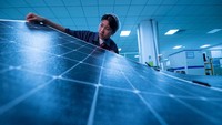 Seorang pekerja memperlihatkan panel surya di pabrik Sunman Energy, Jiangshu, China, Selasa (14/6/2022).