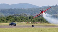 Sebuah pesawat akrobatik terbang di sebelah supercar listrik buatan Kroasia, Rimac Nevera, di bandara Varazdin, Kroasia Utara, Sabtu (11/6/2022) waktu setempat.  
