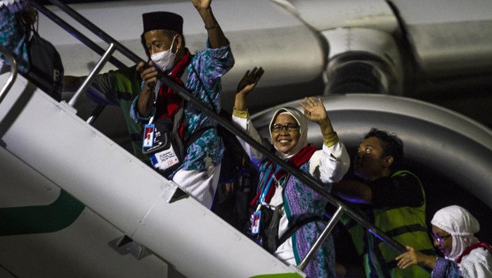 Jamaah calon haji melambaikan tangan saat menaiki tangga menuju pesawat Airbus 330-300 di Bandara Internasional Syamsudin Noor, Banjarbaru, Kalimantan Selatan, Minggu (12/6/2022) malam. Sebanyak 360 jamaah calon haji kelompok terbang (kloter) pertama embarkasi Banjarmasin Kalimantan Selatan dan Kalimantan Tengah diberangkatkan menuju tanah suci Arab Saudi. ANTARA FOTO/Bayu Pratama S/aww.