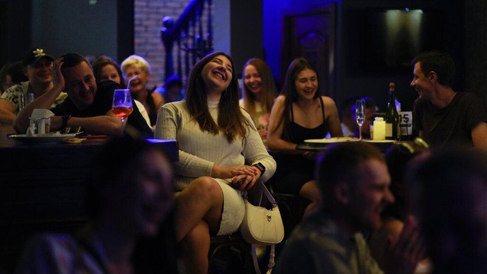 Begini Cara Warga Tetap Waras di Tengah Kengerian Perang Ukraina People attend Serhiy Lipko's stand-up comedy show in Kyiv, Ukraine, Saturday, June 11, 2022. The war in Ukraine isn't remotely funny, but Ukrainians are learning to laugh about the awfulness of it all. Not necessarily because they want to, but because they have to stay sane in the conflict that has killed tens of thousands and is turning Ukraine, millions of lives, and the world order inside out. (AP Photo/Natacha Pisarenko)