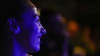Seorang wanita tersenyum kala melihat aksi Lipko di panggung.