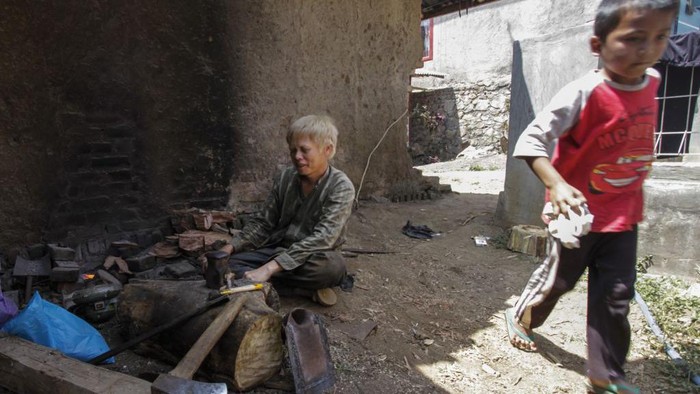 GARUT, WEST JAVA, INDONESIA - JUNE 09: Firman 44 years old accompanied by his wife during activities drying tobacco in Ciburuy Village, Garut Regency, West Java Province, on June 09, 2022. According to villagers living in Ciburuy Village, there are 10 teenagers and adults albinism diagnosed people who study and work outside the village. Albinism is a genetic condition that causes a person to lack color pigment. Due in the skin and hair, a unique pigment that is not the same as other residents around the village, albinism people are sometimes getting ridiculed and insulted. Thatâs why, albinism residents are forced to stop going to school, since they loses their confidence. But on the other hand, over time, the local residents begin to embrace and make albinism friends as a daily habit. This village also has quite unique rules. One of them is, it is forbidden to make a visit on Tuesdays and Fridays. This is a taboo that has been passed down from generation to generation since the ancestors of the residents of Kampung Ciburuy and has never been violated by the community. (Photo by Dasril Roszandi/Anadolu Agency via Getty Images)