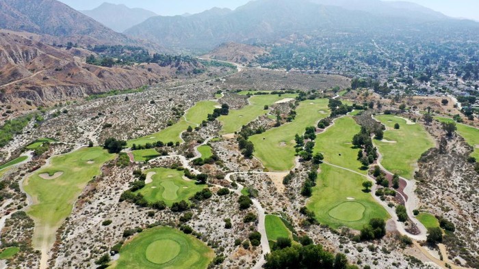 Diterpa Kekeringan, Lapangan Golf di AS Mulai Tandus SANTA CLARITA, CALIFORNIA - JUNE 14: An aerial view of a section of the Sand Canyon Country Club (L) in Los Angeles County on June 14, 2022 in Santa Clarita, California. Drought restrictions are being imposed on golf courses in parts of Southern California with some course managers saying they are prepared to have some areas of green grass go brown. Golf courses in Los Angeles which use recycled water are not subject to the same restrictions as those which use potable water. A water shortage emergency has been declared in Southern California with water restrictions which began June 1st for 6 million residents amid drought conditions. (Photo by Mario Tama/Getty Images)