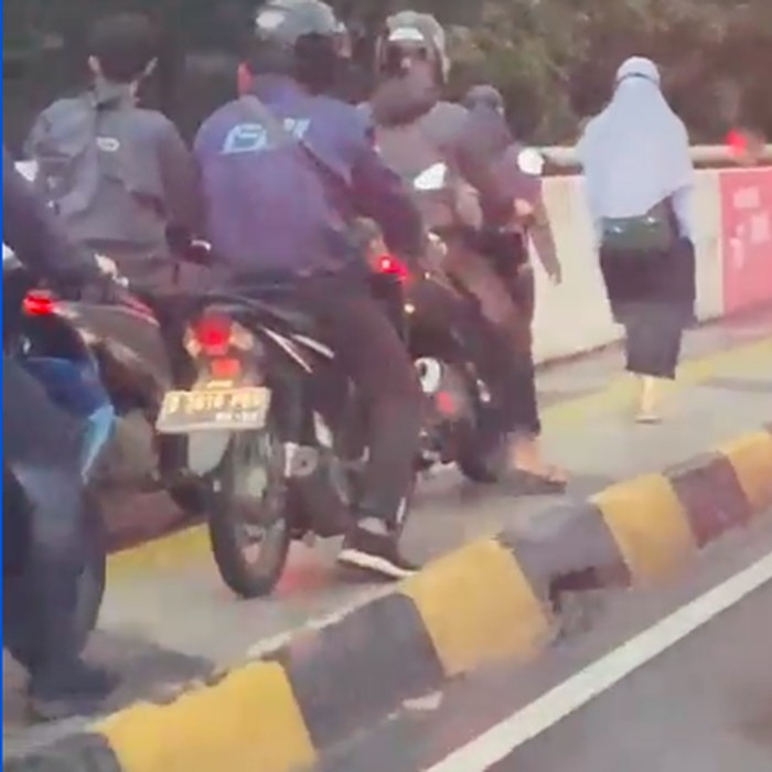 Dua perempuan pejalan kaki tak mau mengalah dari invasi pemotor bandel. (Tangkapan layar video Alfionita Jaelani)
