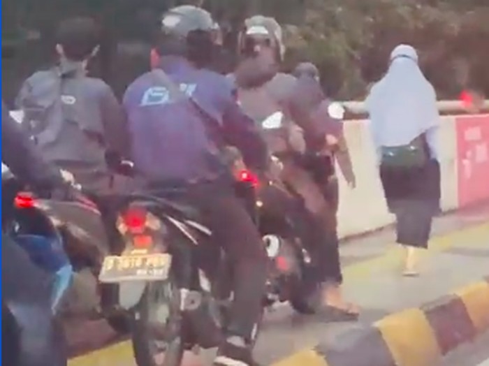 Dua perempuan pejalan kaki tak mau mengalah dari invasi pemotor bandel. (Tangkapan layar video Alfionita Jaelani)