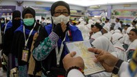 Petugas memeriksa paspor milik calon haji kelompok terbang (kloter) pertama embarkasi Batam di Asrama Haji Batam, Kepulauan Riau, Rabu (15/6/2022). 