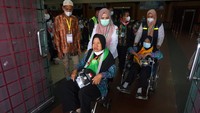 Dua petugas mendorong kursi roda dua jamaah calon haji asal Kalimantan Barat embarkasi Batam menuju bus Damri sebelum keberangkatan di Kapuas Palace, Pontianak, Kalimantan Barat, Rabu (15/6/2022). 