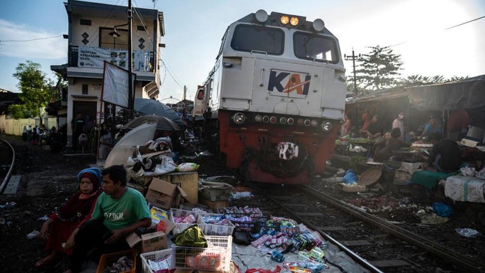 Pemandangan tak biasa terlihat di Surabaya. Di salah satu area terlihat pedagang menjajakan beragam baju hingga makanan di pinggir rel kereta. Ini penampakannya
