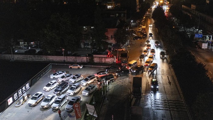 Potret Mobil-mobil di Wuhan Serbu SPBU Sebelum Harga BBM Naik Antrean panjang kendaraan roda empat terlihat di SPBU kawasan Wuhan, China. Mereka antre isi bensin sebelum harga BBM naik. Ini fotonya.
