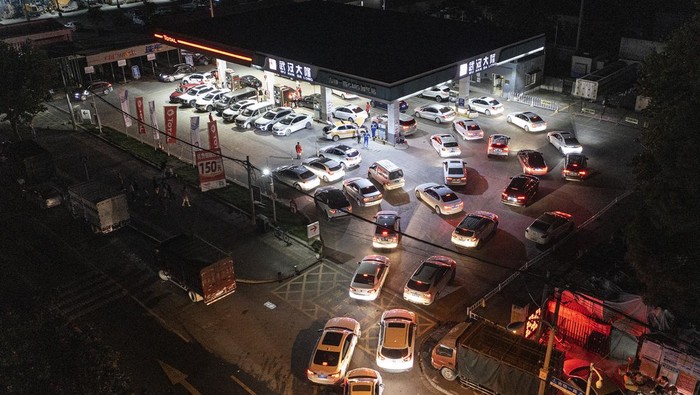 Antrean panjang kendaraan roda empat terlihat di SPBU kawasan Wuhan, China. Mereka antre isi bensin sebelum harga BBM naik. Ini fotonya.
